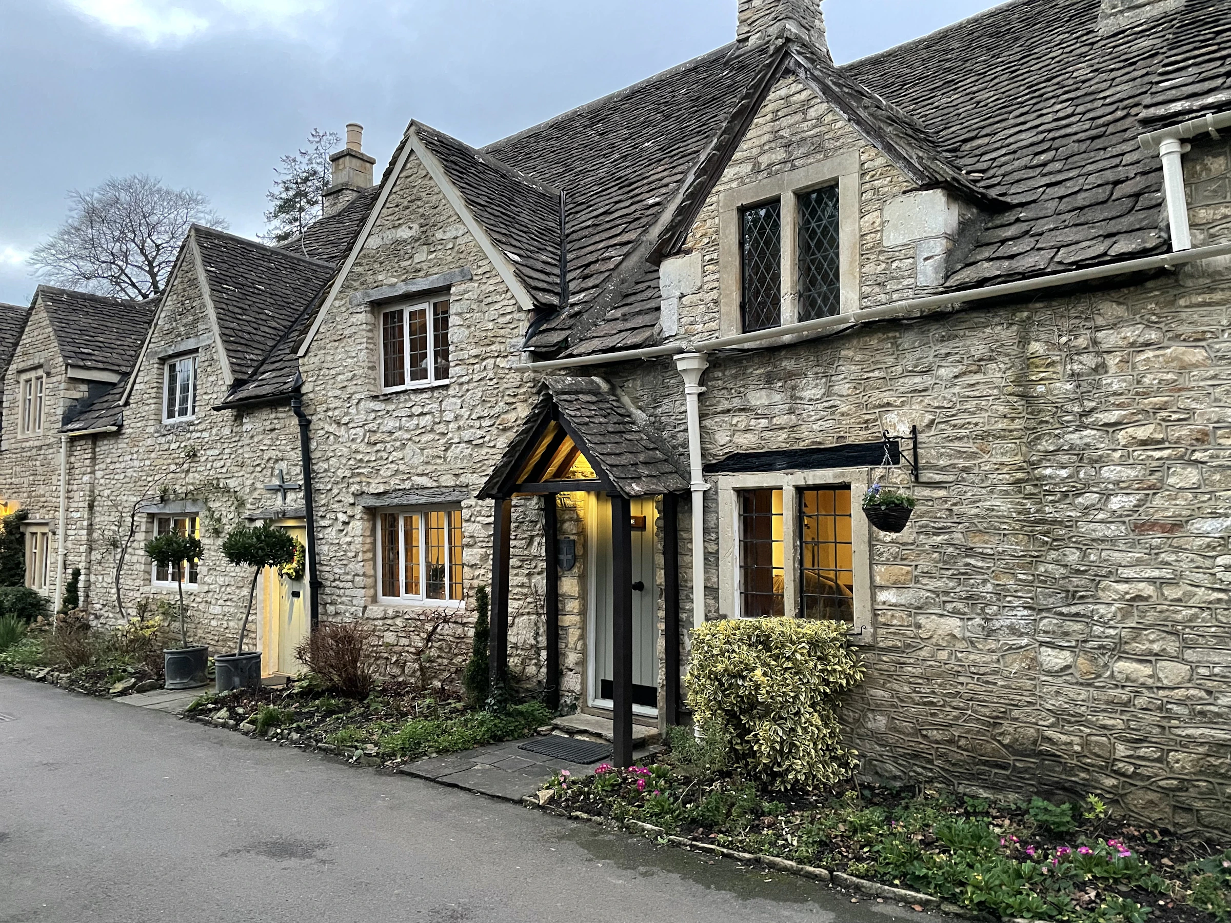 Traditional stone cottages with pitched roofs on West Street in Castle Combe