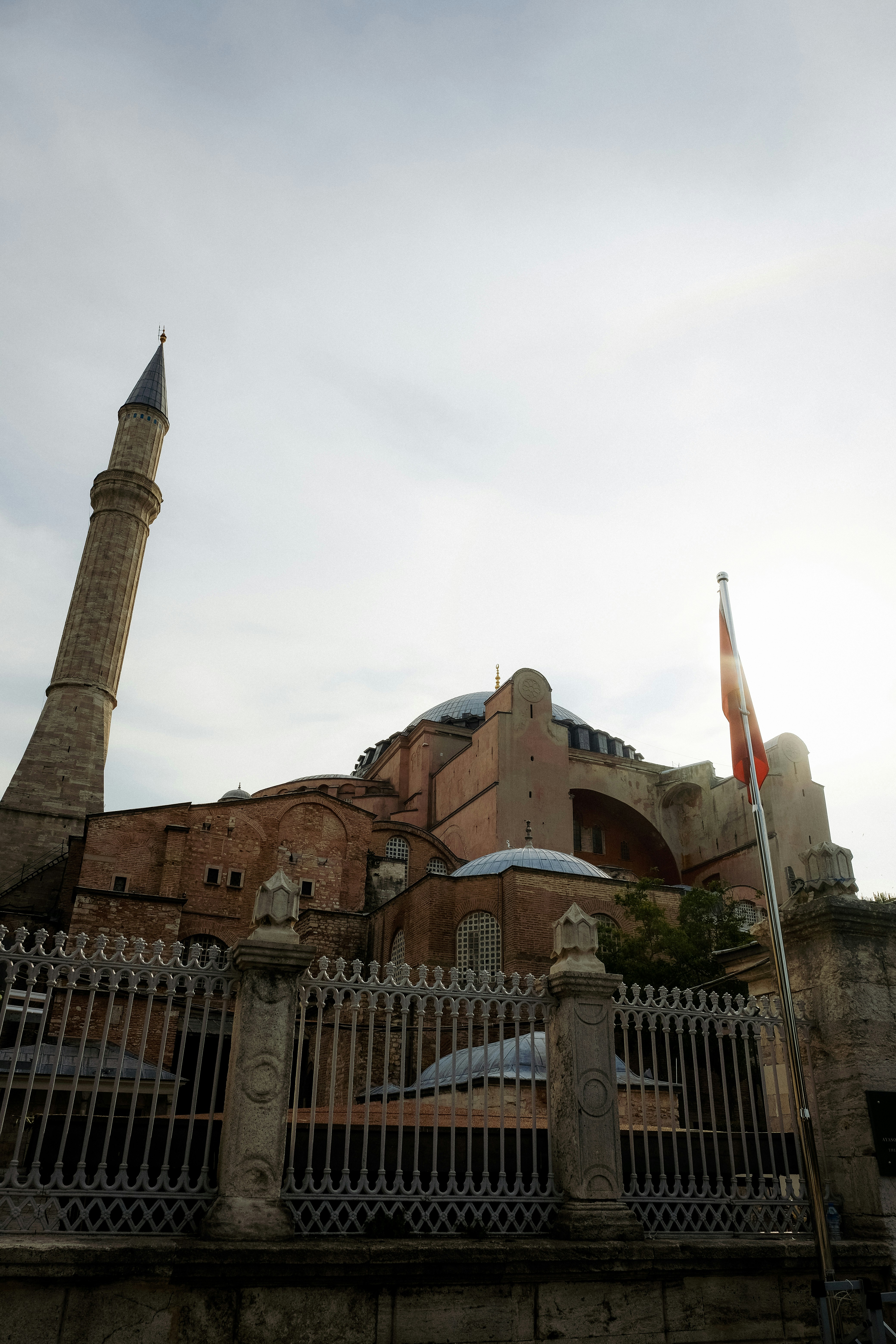 a building with a fence and a tower with a flag on it