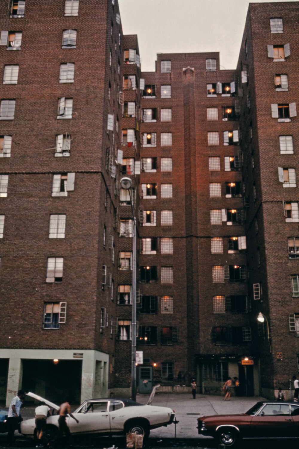 a couple of cars parked in front of a tall building