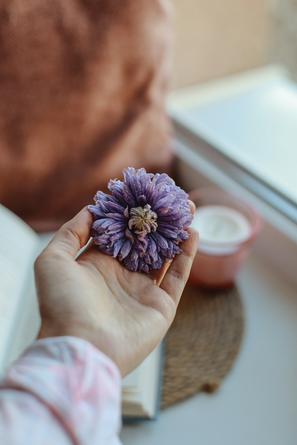 a person holding a purple flower