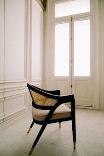 a chair sitting in front of a window in a room