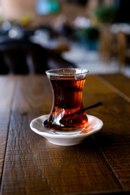 a glass of liquid on a saucer
