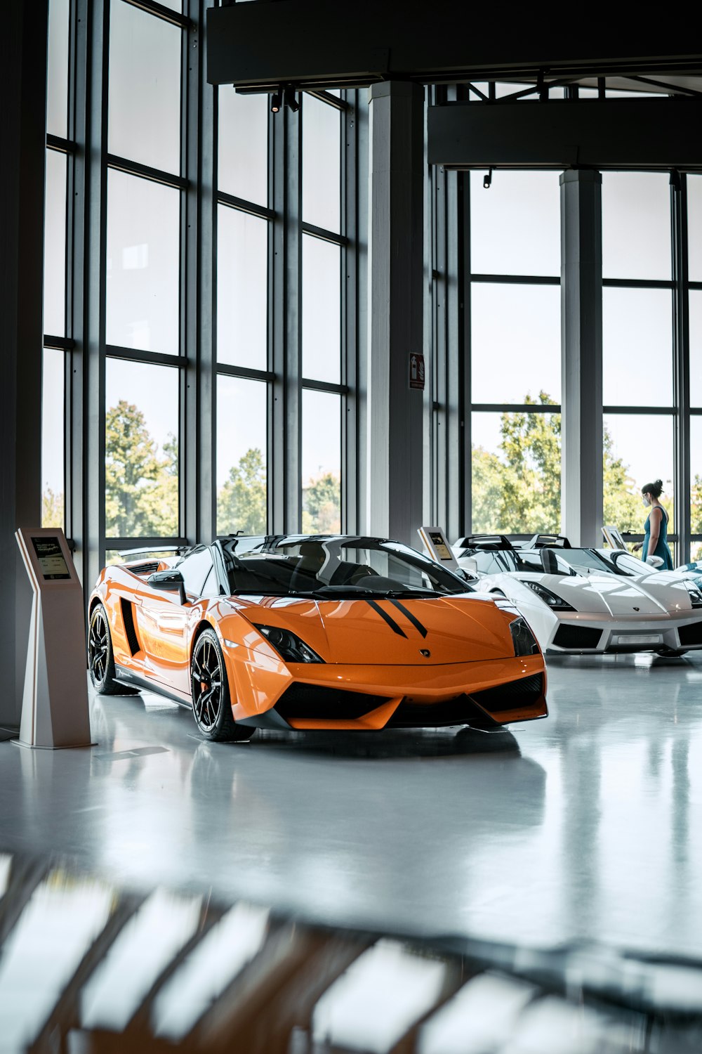 a yellow sports car parked in a room with a large window