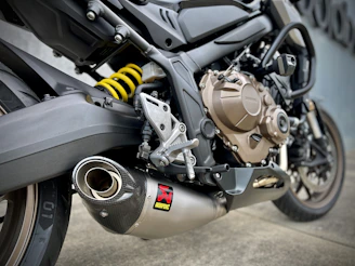 Several motorcycle exhausts lined up, showcasing different designs and finishes under natural light.
