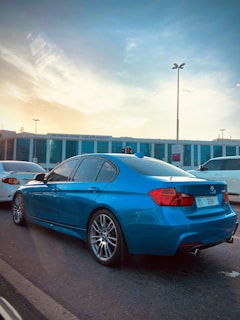 Red sedan car parked on a city street at sunset