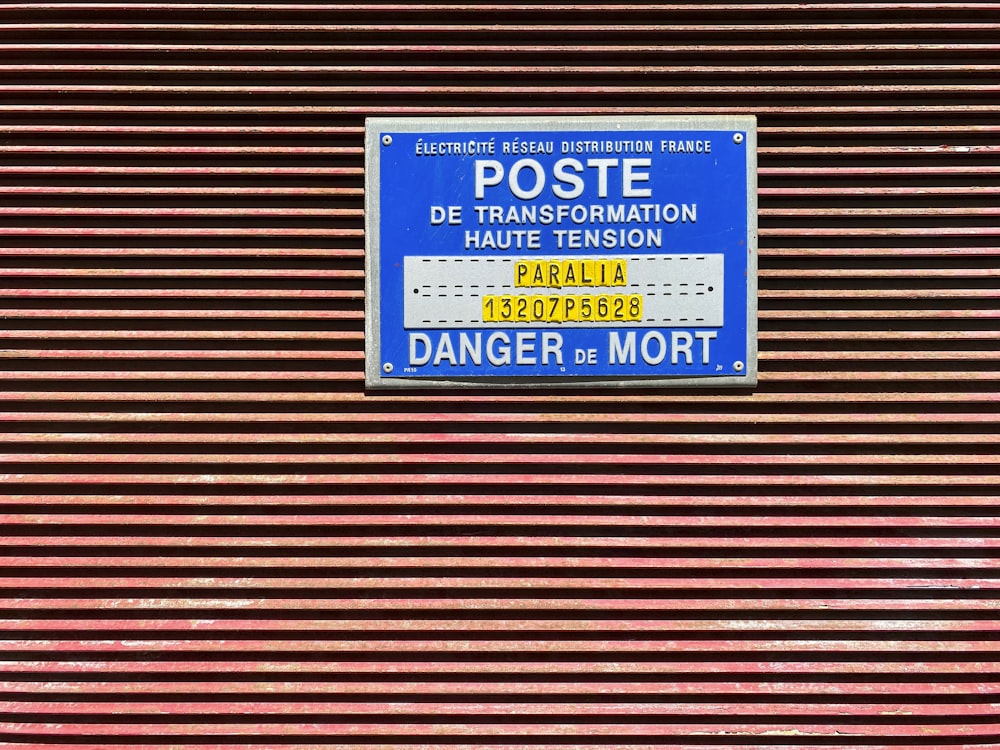 a blue and white sign on a red wall
