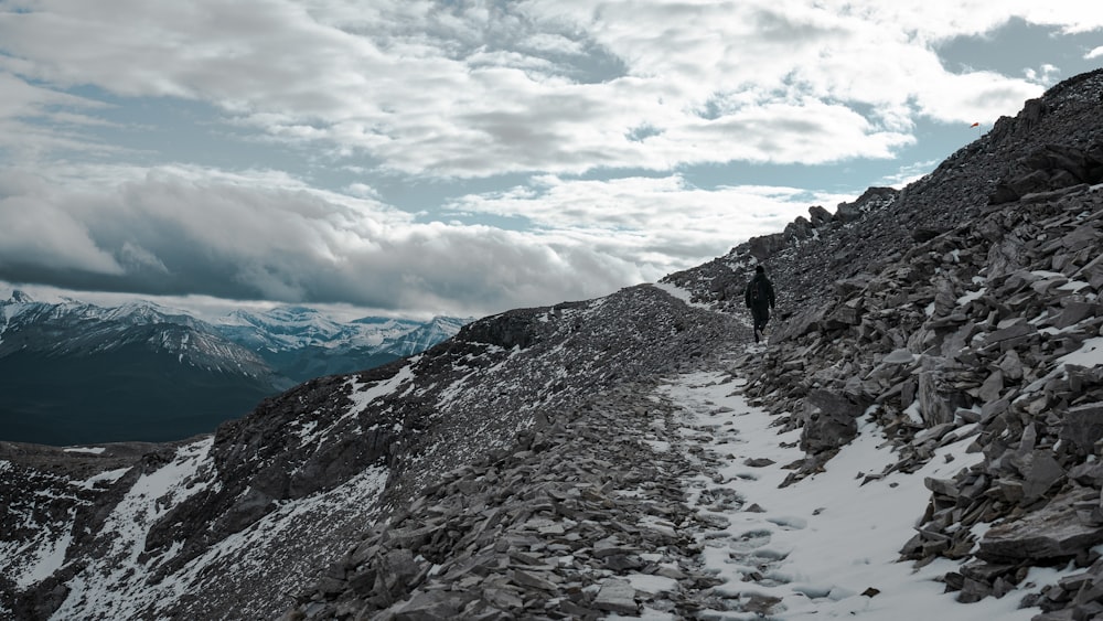Una persona caminando sobre una montaña rocosa