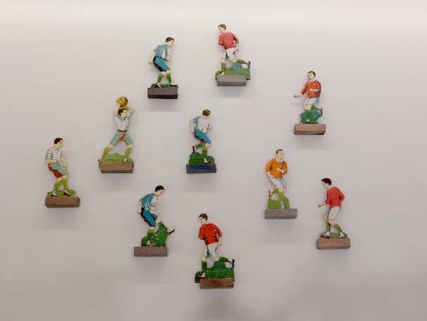 A collection of kids' toys featuring miniature soccer balls and jerseys arranged on a wooden table