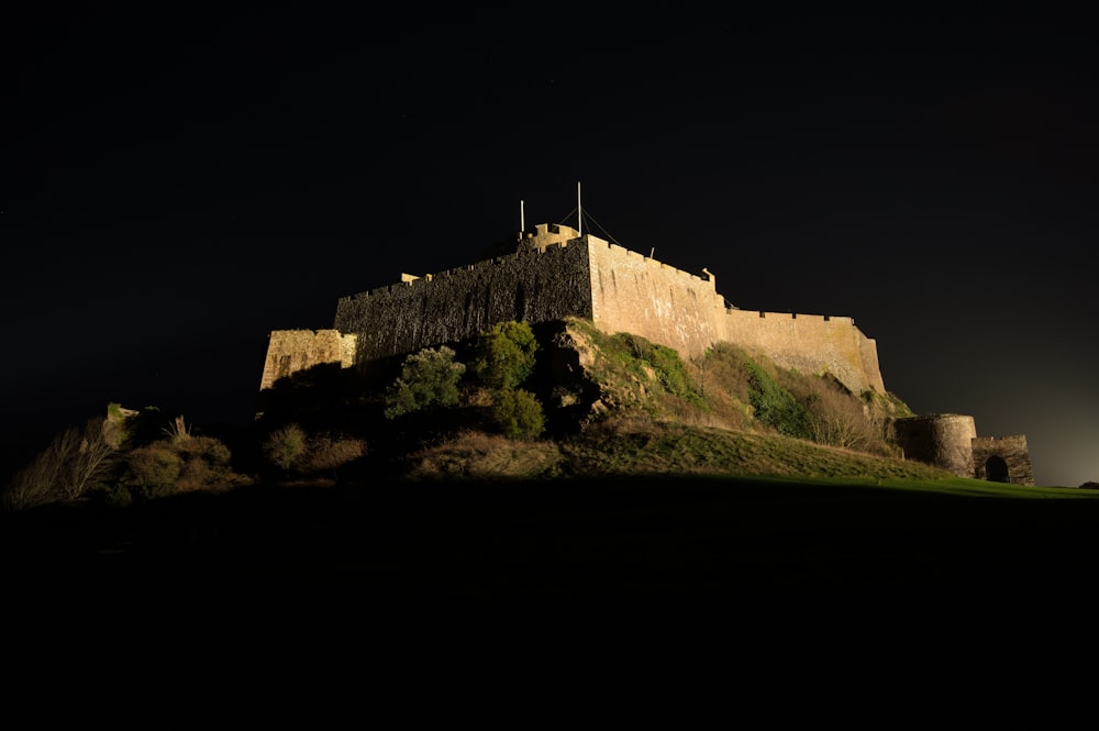 a stone castle on a hill with Edinburgh Castle in the background