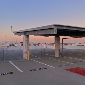 a large concrete structure with a road and a parking lot