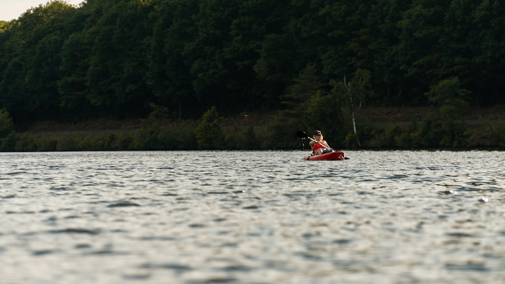 a person in a red kayak on a lake