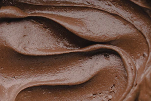 Smooth swirls of dark chocolate frosting with a glossy texture