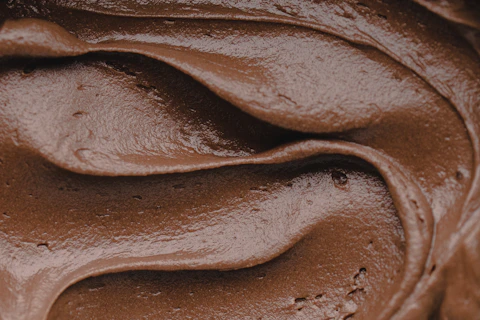 Smooth swirls of dark chocolate frosting with a glossy texture