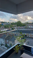 Balcony view overlooking a quiet neighborhood with greenery.