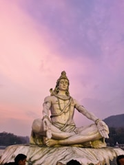 A serene and devotional image of Lord Shiva meditating in the Himalayas at dawn.