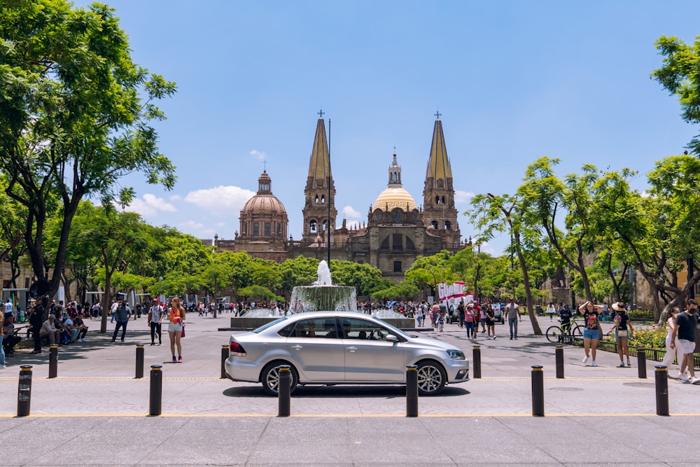 a car parked in front of a building with towers and spires