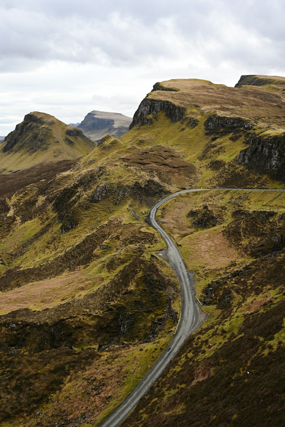 una strada tortuosa attraverso una valle con Quiraing sullo sfondo