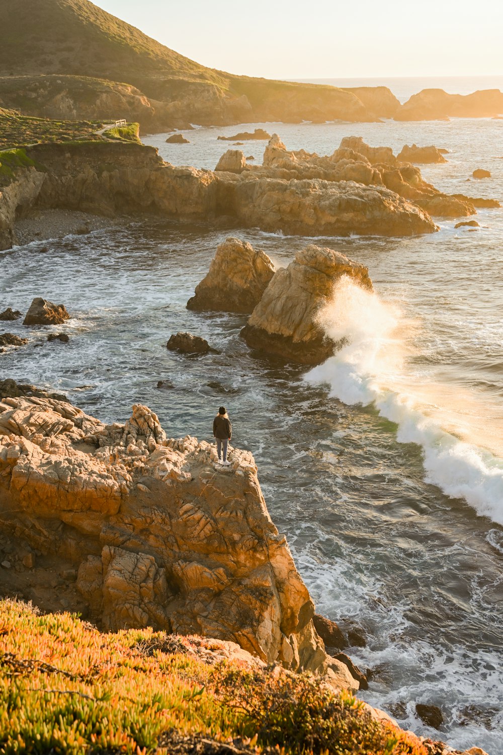 a person standing on a rock in the water