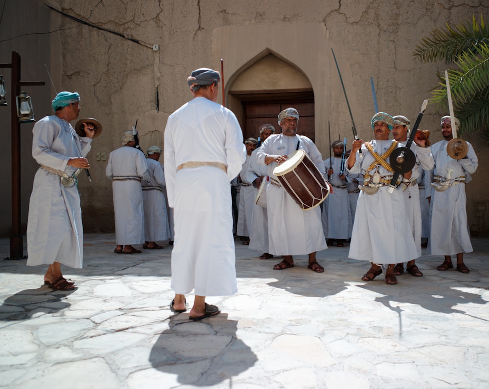Eine Gruppe von Menschen, die weiße Gewänder tragen und Instrumente halten