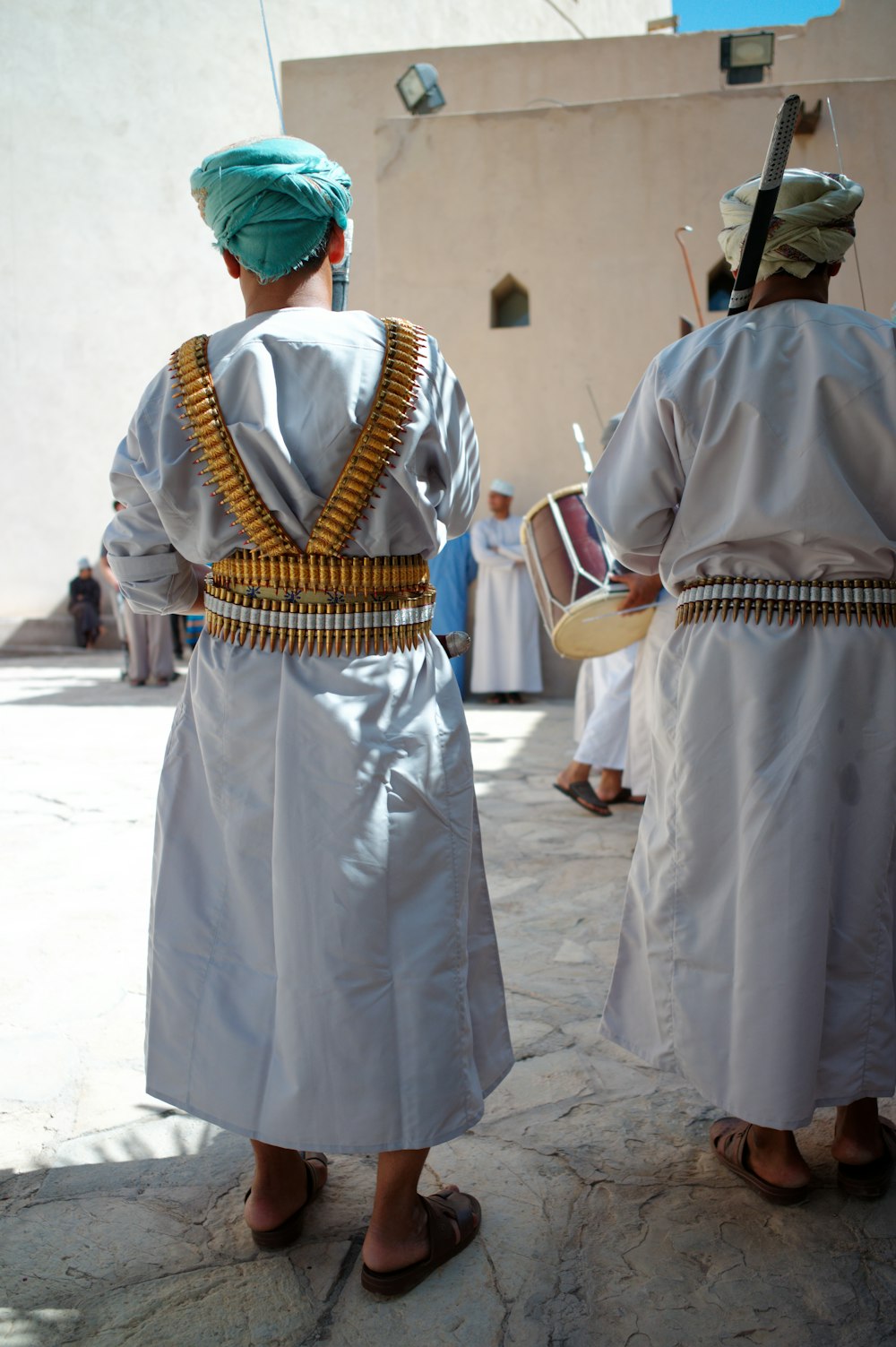 a couple of people wearing white robes and holding buckets