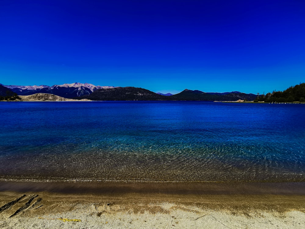 una spiaggia con uno specchio d'acqua e montagne sullo sfondo