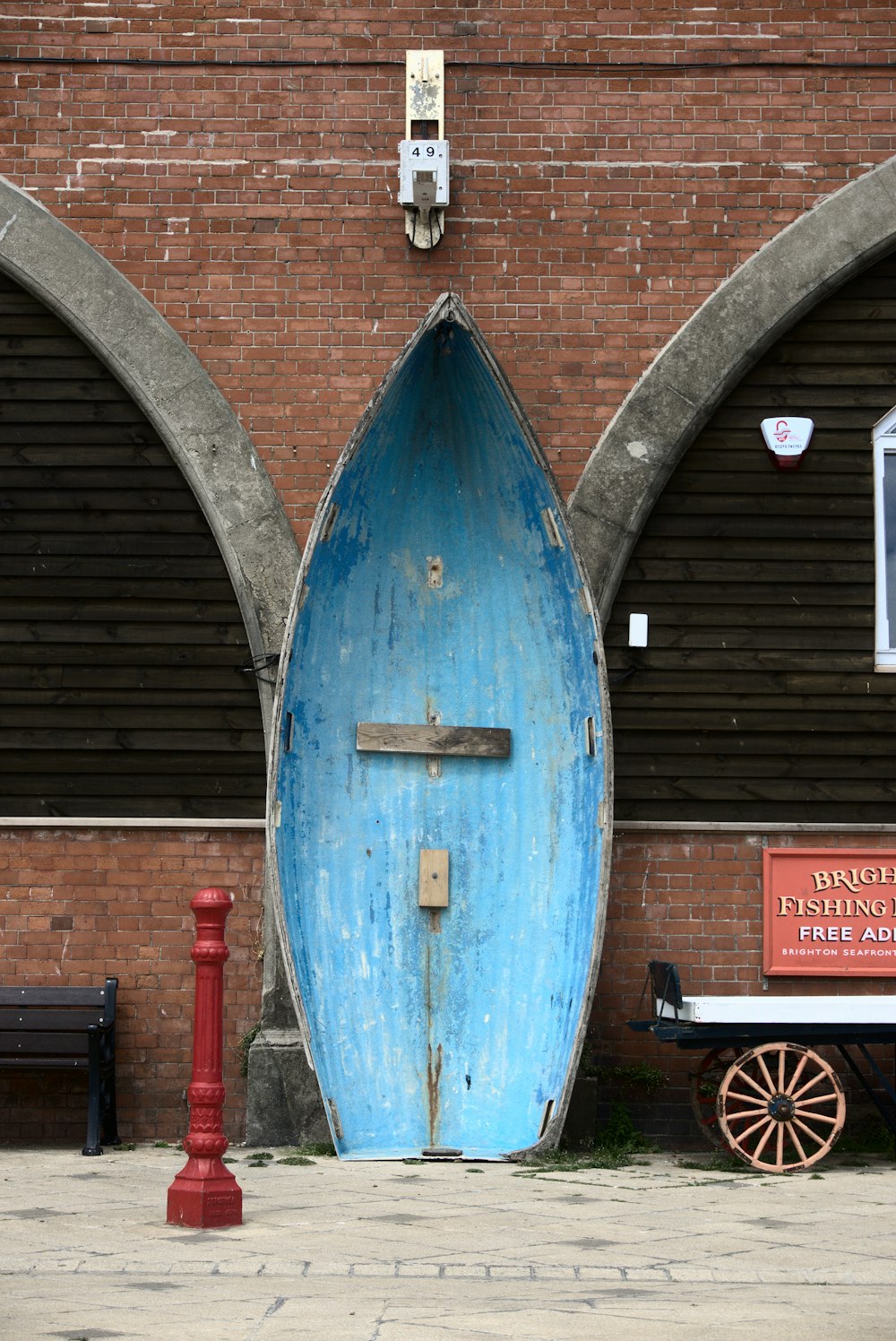 a blue barrel in front of a brick building