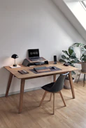A sleek office desk with a laptop and minimalist decor in natural light.