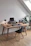 A cozy, minimalist home office setup with natural light and wooden desk accessories.