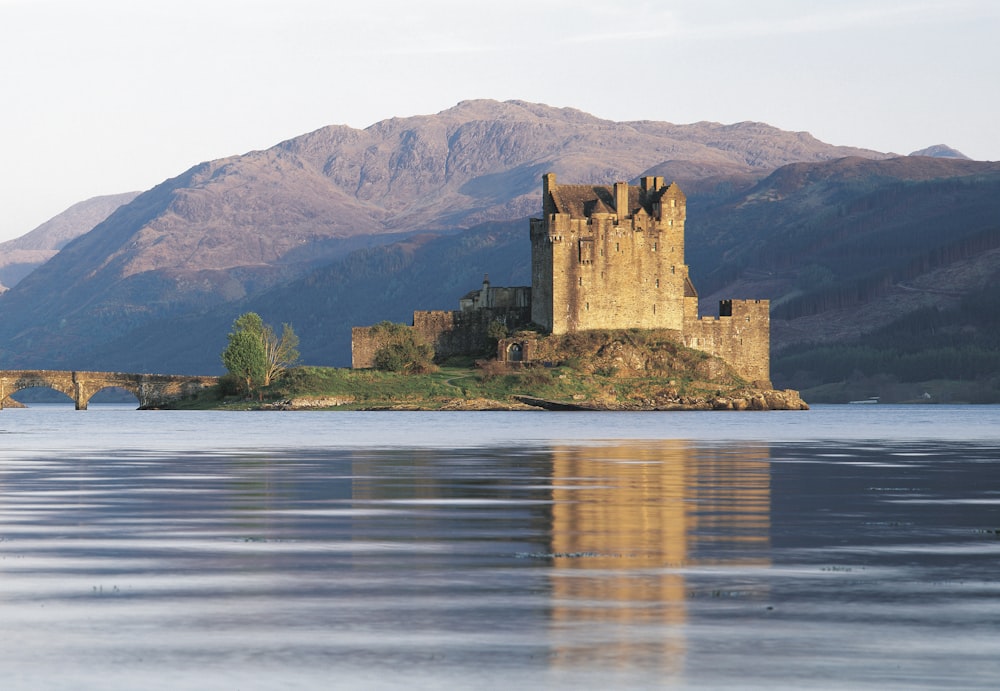 um castelo em uma ilha com Eilean Donan ao fundo