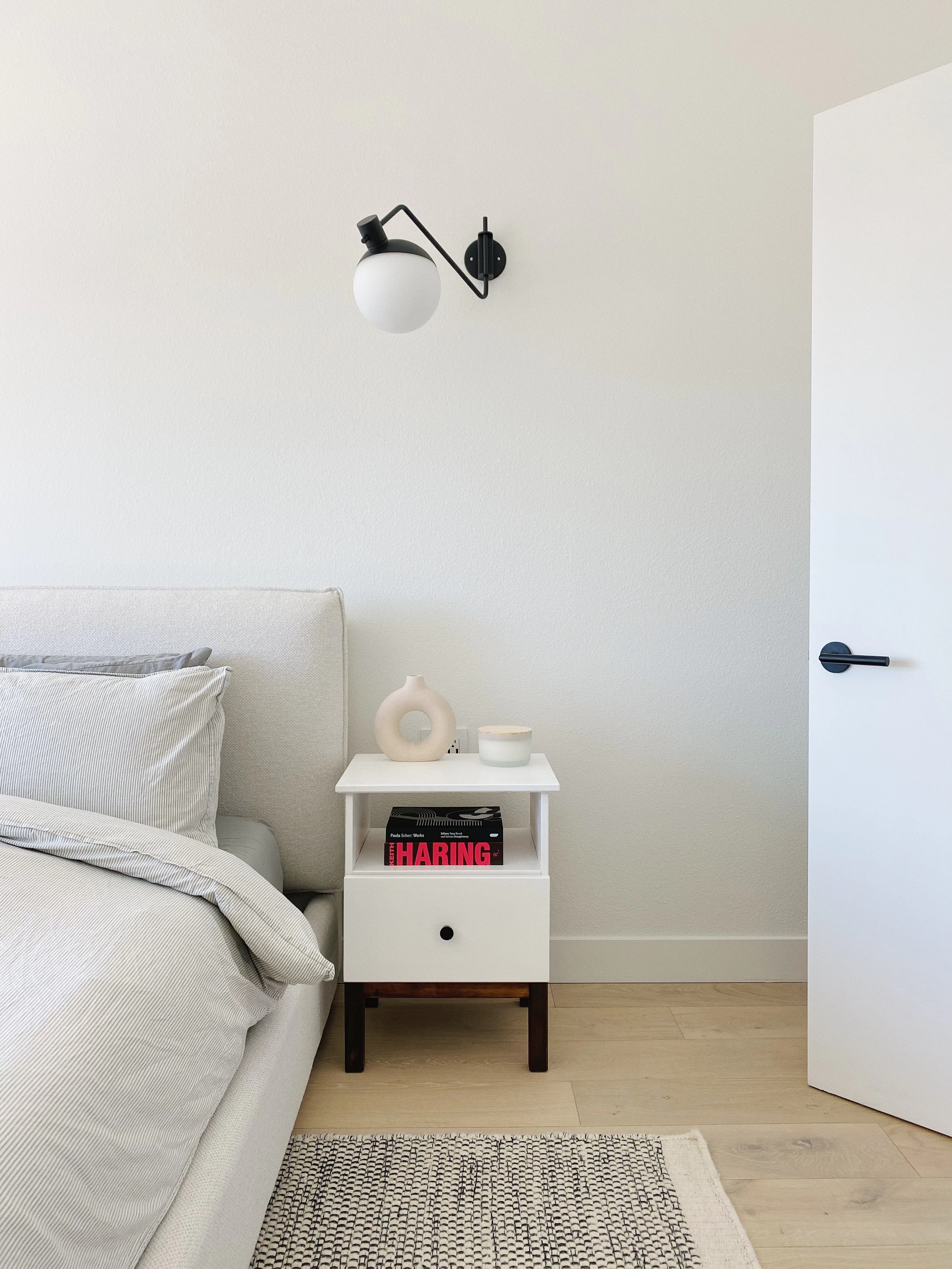 A white room with a bed and a table