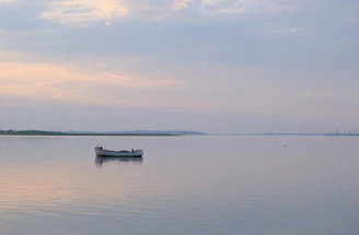 A serene morning scene of a fishing boat gliding over calm Florida waters under soft pastel skies.