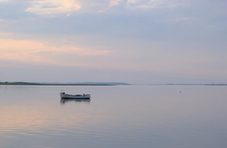 A serene morning scene of a fishing boat gliding over calm Florida waters under soft pastel skies.