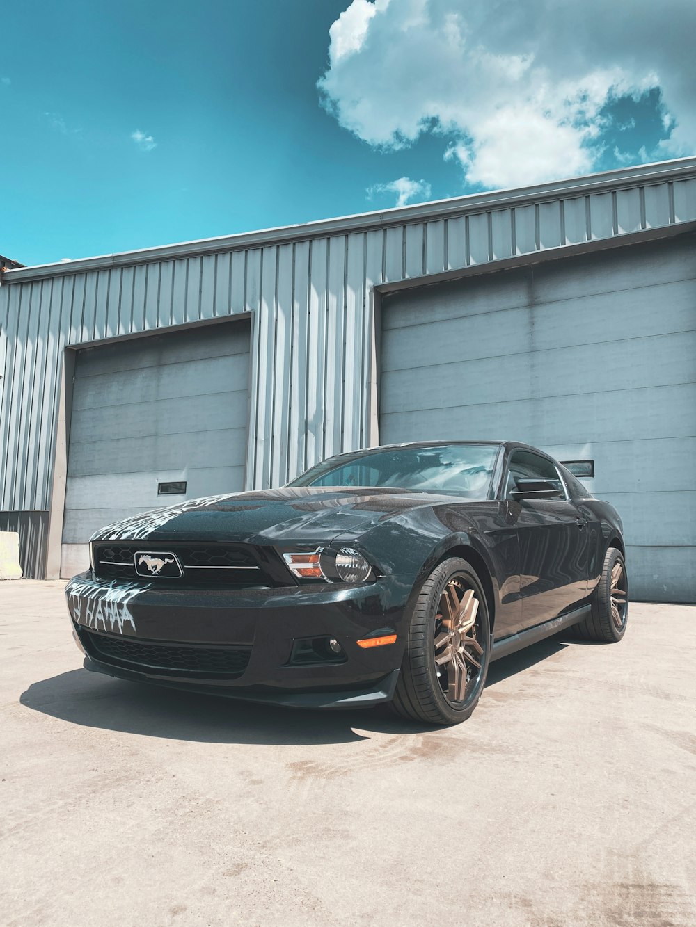 a black sports car parked in front of a garage