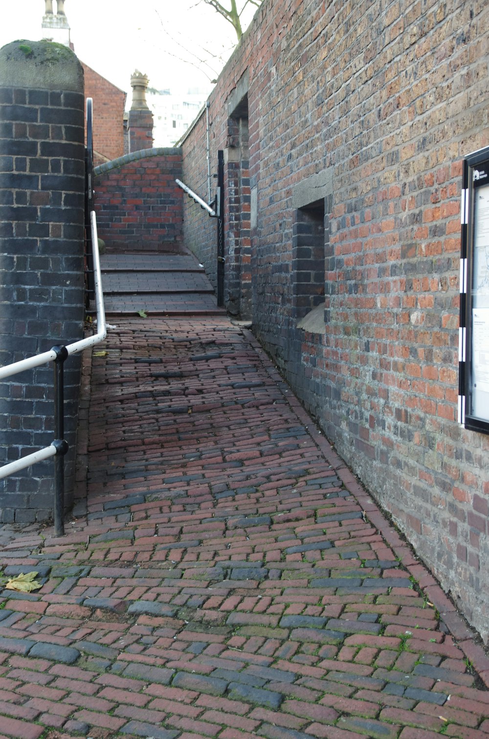 a brick walkway between two buildings