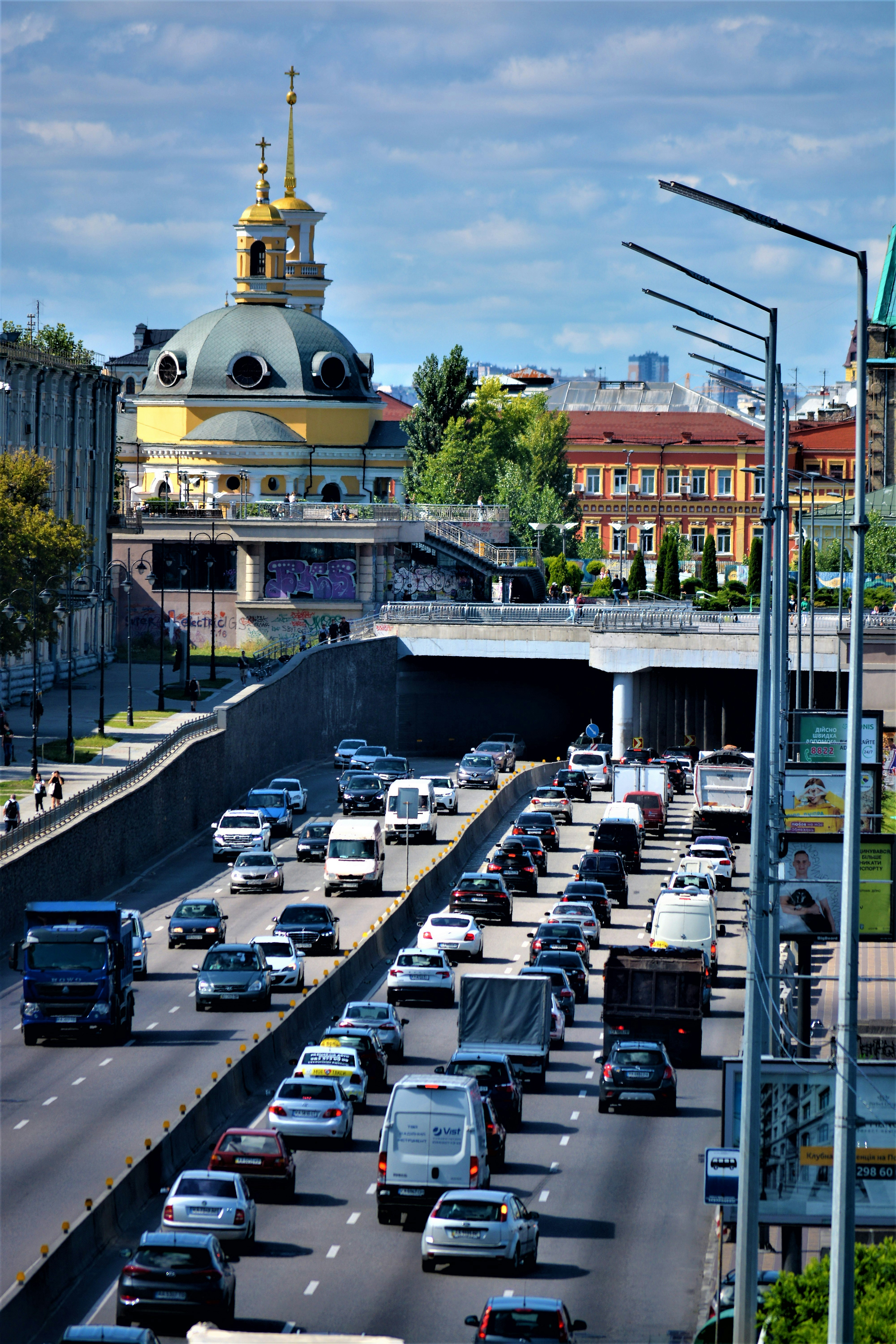 a busy street with cars and a domed building in the background