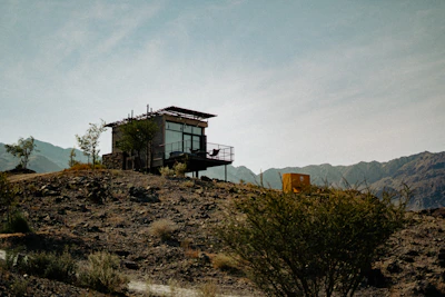 Modern cabin structure with large windows showcasing a mountain view.
