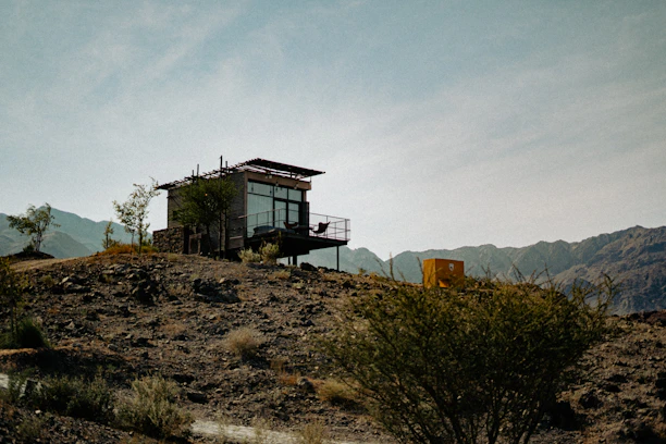 A sleek, modern portable cabin set against a bustling Qatar industrial site under clear skies.