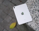 An elegant white iPad displayed on a clean black surface.