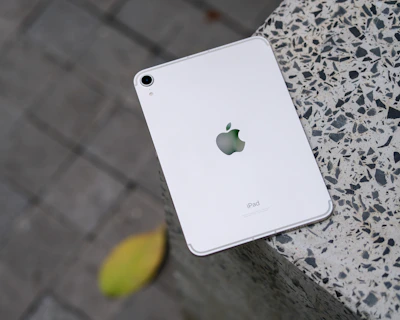 An elegant white iPad displayed on a clean black surface.