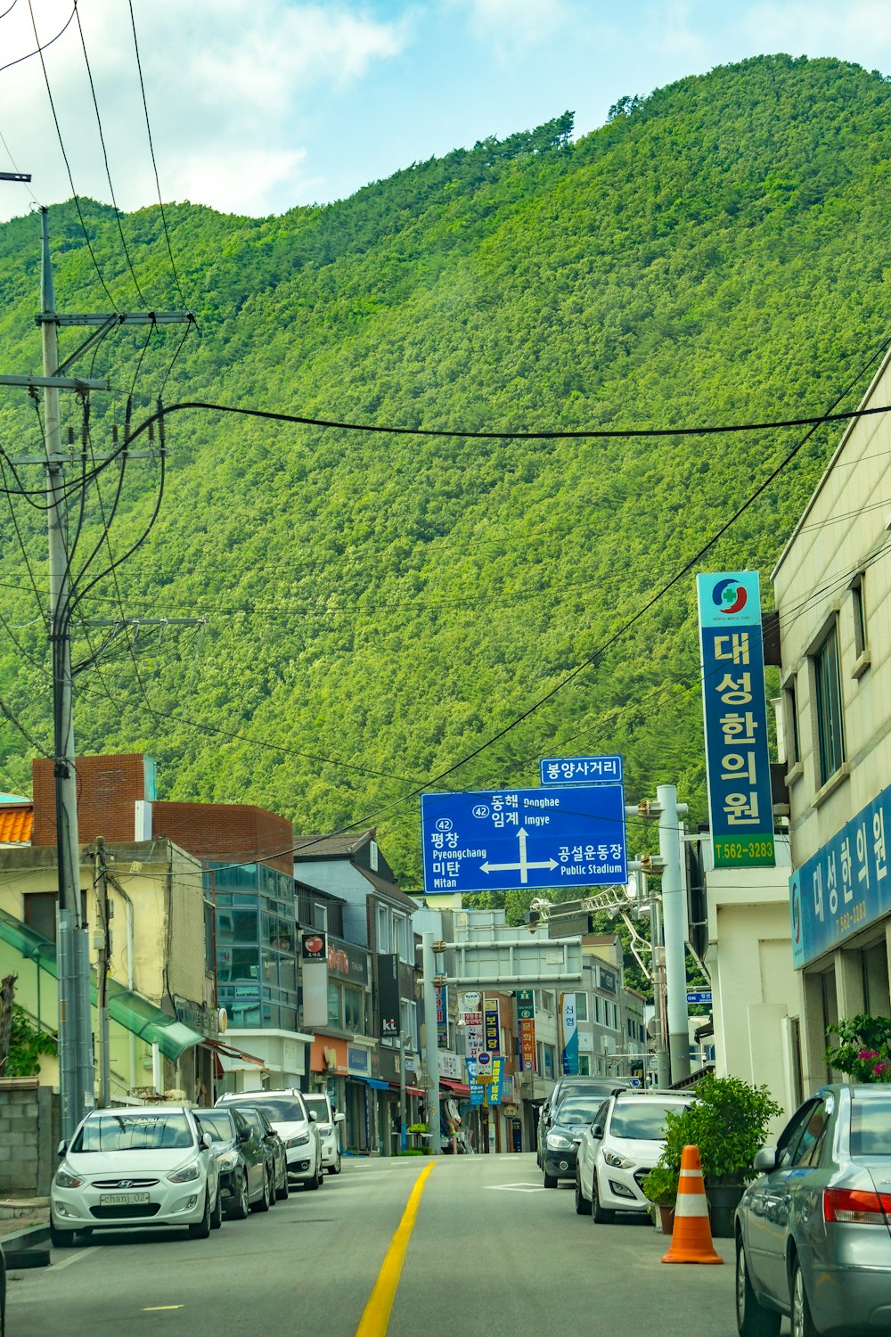 a street with cars and trees on the side