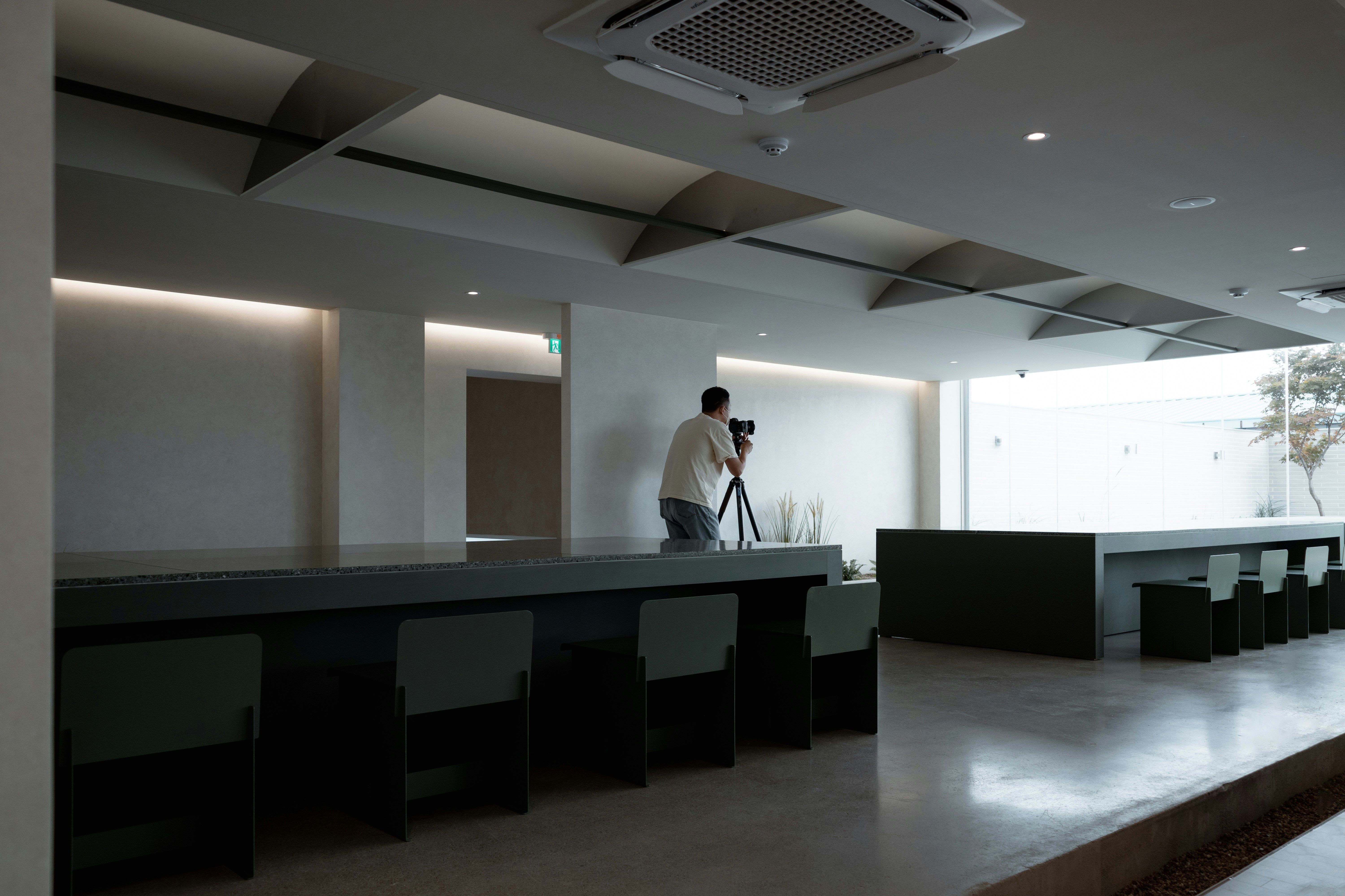 a person taking a picture of a room with a large table and chairs