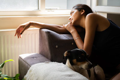 a woman sitting on a couch with a dog