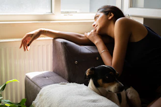 a woman sitting on a couch with a dog