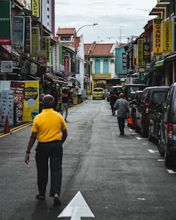 A bustling city street with people walking and colorful buildings.