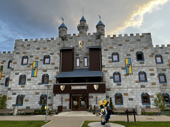A colorful Minecraft castle with tall towers and flags waving in the breeze.