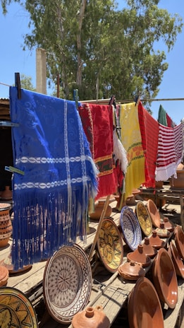 Soft, embroidered bibs hanging gently on a clothesline outdoors.