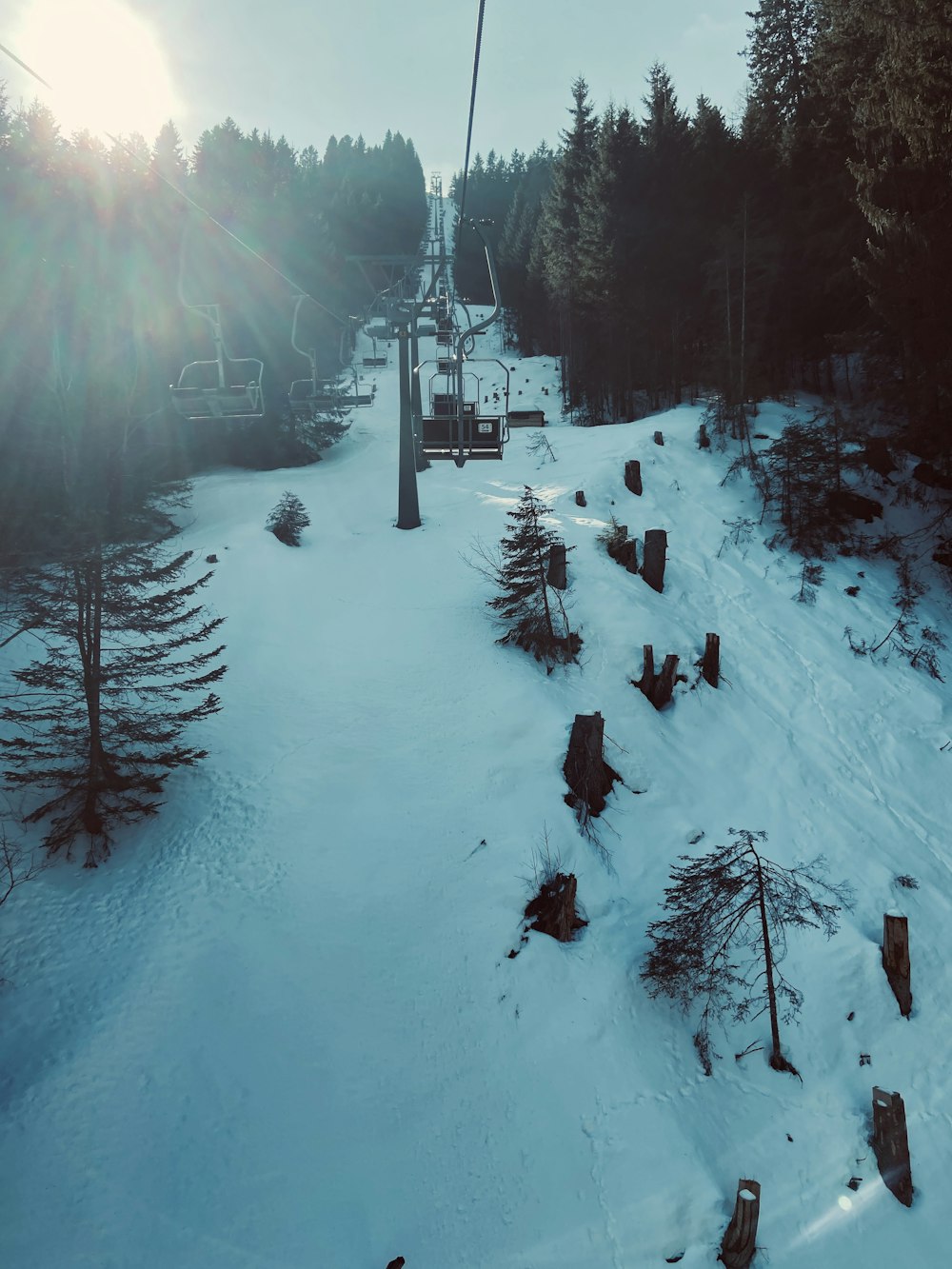 a ski lift going up a snowy hill