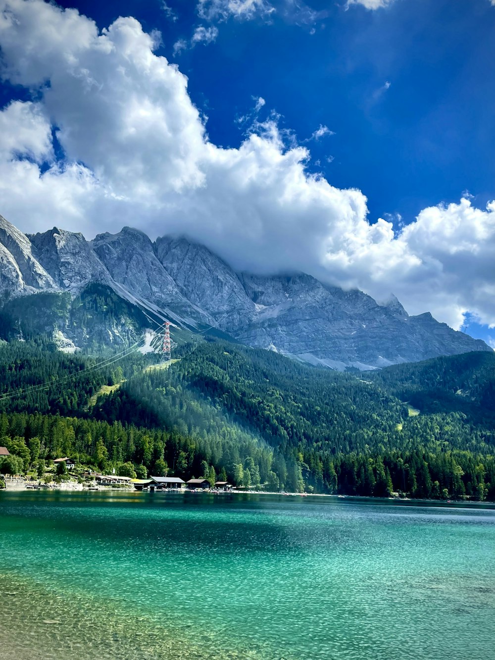 a lake with trees and mountains in the background