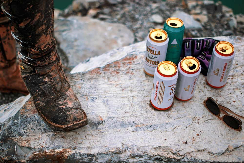 a group of cans and a shoe on a rock