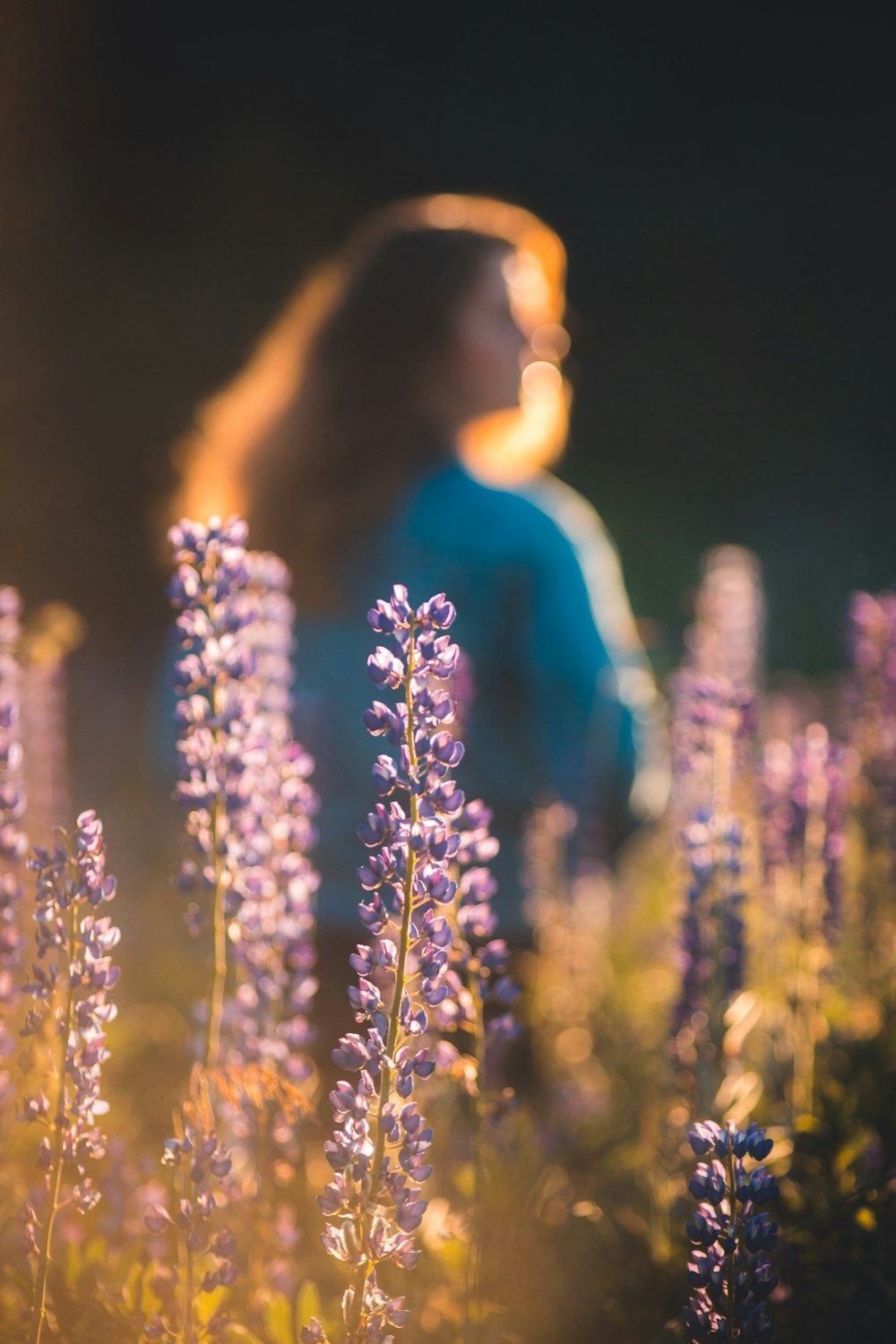 a person standing behind a flower